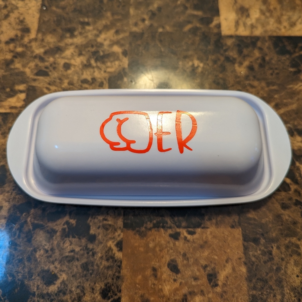 Butter dish with red vinyl lettering. Dish is melamine and white in color